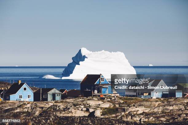 houses and iceberg in qeqertarsuaq - greenland stockfoto's en -beelden