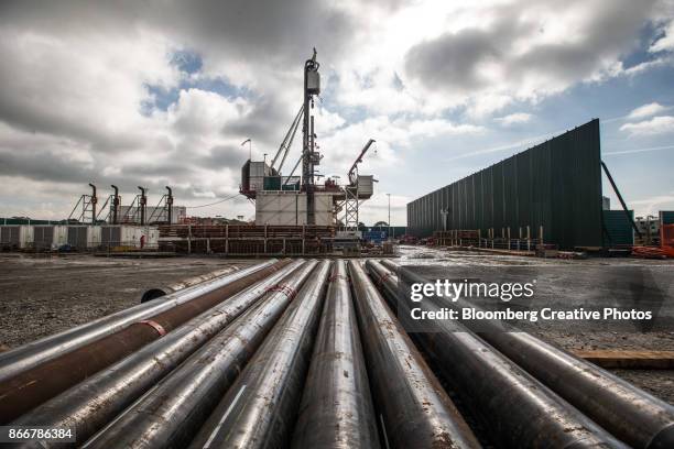 casing lies on the ground in front of the drill rig at a pilot gas well site - fraccen stockfoto's en -beelden