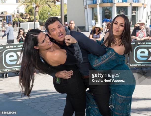 Nikki Bella and Brie Bella wrestle Mark Wright at "Extra" at Universal Studios Hollywood on October 26, 2017 in Universal City, California.