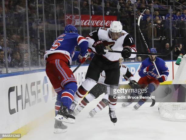 Nick Holden of the New York Rangers is hit by Brendan Perlini of the Arizona Coyotes during the first period at Madison Square Garden on October 26,...