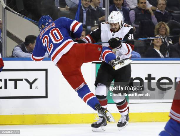 Chris Kreider of the New York Rangers is hit by Zac Rinaldo of the Arizona Coyotes during the first period at Madison Square Garden on October 26,...