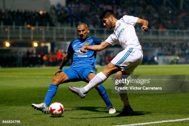 Marco Asensio of Real Madrid competes for the ball with Cata Diaz of Fuenlabrada during the Copa del Rey round of 32 first leg match between...