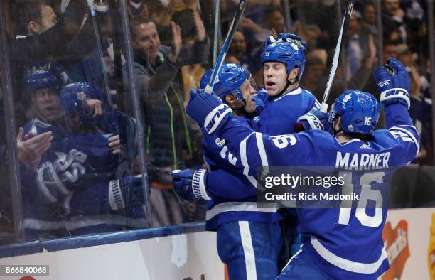 Toronto Maple Leafs center Dominic Moore gets a hug from Toronto Maple Leafs left wing Matt Martin as Toronto Maple Leafs center Mitchell Marner...