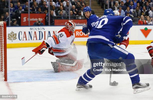 Toronto Maple Leafs center Dominic Moore backhands a goal past Carolina Hurricanes goalie Scott Darling . Toronto Maple Leafs VS Carolina Panthers...