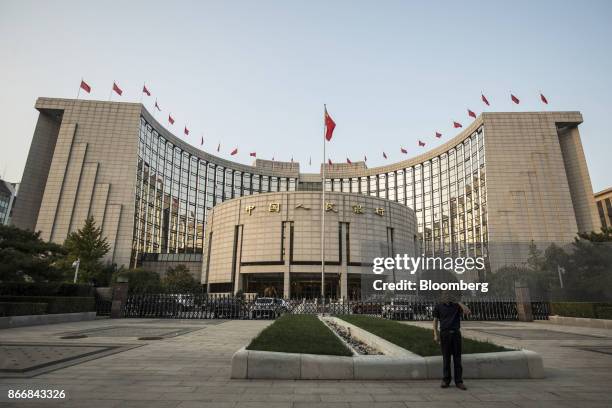 Man talks on a mobile phone outside the People's Bank of China headquarters in Beijing, China, on Monday, Oct. 23, 2017. China's central bank is said...