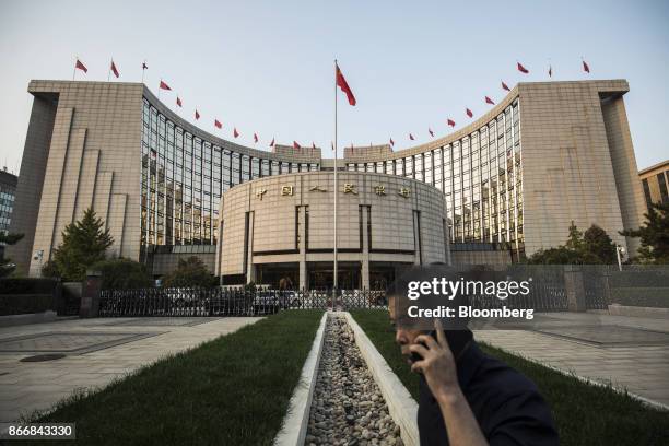 Man talks on a mobile phone outside the People's Bank of China headquarters in Beijing, China, on Monday, Oct. 23, 2017. China's central bank is said...