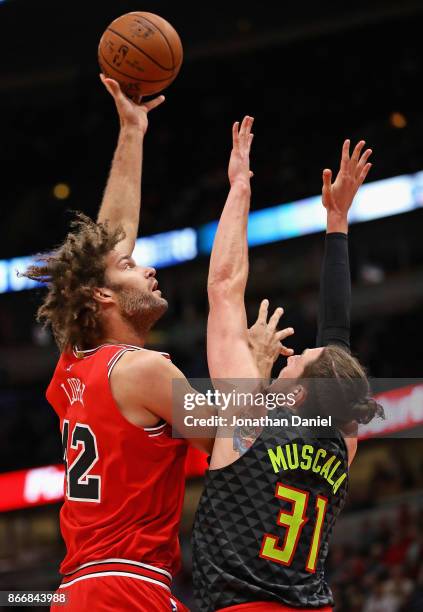 Robin Lopez of the Chicago Bulls puts up a shot over Mike Muscala of the Atlanta Hawks at the United Center on October 26, 2017 in Chicago, Illinois....