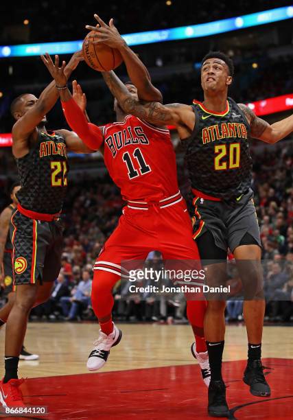Isaiah Taylor and John Collins of the Atlanta Hawks knock the ball away from David Nwaba of the Chicago Bulls at the United Center on October 26,...