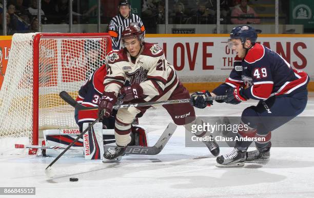 Cole Coskey of the Saginaw Spirit skates to check Jonathan Ang of the Peterborough Petes in an OHL game at the Peterborough Memorial Centre on...