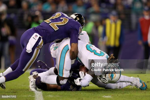 Running Back Jay Ajayi of the Miami Dolphins is tackled by cornerback Jimmy Smith of the Baltimore Ravens in the first quarter at M&T Bank Stadium on...