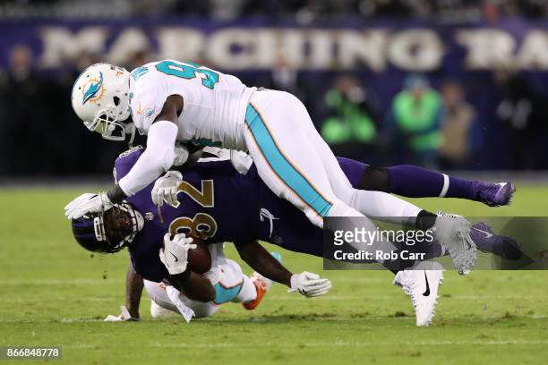 Tight End Benjamin Watson of the Baltimore Ravens is tackled after a catch by defensive tackle Vincent Taylor of the Miami Dolphins at M&T Bank...