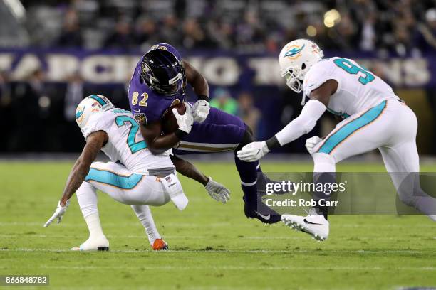 Tight End Benjamin Watson of the Baltimore Ravens is tackled after a catch by defensive tackle Vincent Taylor of the Miami Dolphins at M&T Bank...