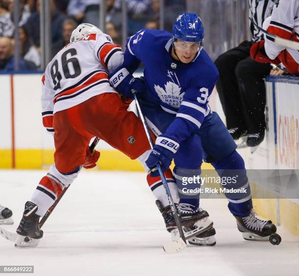 Toronto Maple Leafs center Auston Matthews looks to get the puck back join the offensive end but is thwarted by Carolina Hurricanes left wing Teuvo...