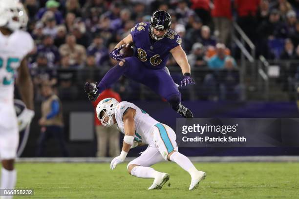 Tight End Nick Boyle of the Baltimore Ravens leaps over middle linebacker Kiko Alonso of the Miami Dolphins in the second quarter at M&T Bank Stadium...