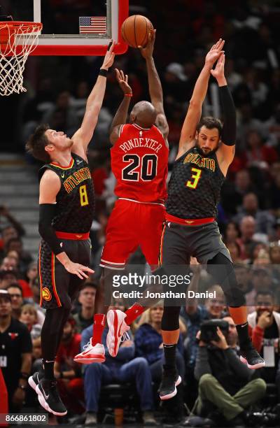 Quincy Pondexter of the Chicago Bulls shoots between Luke Babbitt and Marco Belinelli of the Atlanta Hawks at the United Center on October 26, 2017...