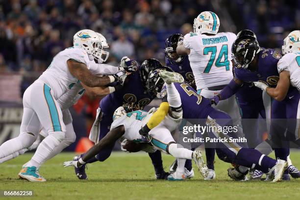 Running Back Jay Ajayi of the Miami Dolphins carries the ball as he is tackled by inside linebacker C.J. Mosley of the Baltimore Ravens in the third...