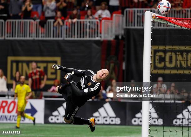 Goalkeeper Brad Guzan of Atlanta United dives to save a shot on goal by the Columbus Crew in extra time during the Eastern Conference knockout round...