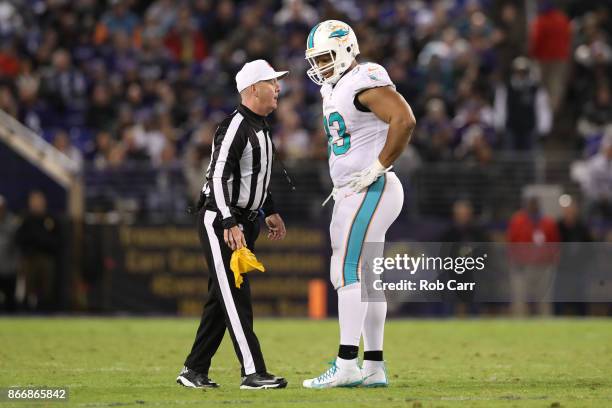 Defensive Tackle Ndamukong Suh of the Miami Dolphins talks with referee John Parry after a play in the third quarter against the Baltimore Ravens at...