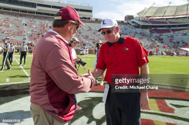 Head coach Jimbo Fisher of the Florida State Seminoles and head coach Bobby Petrino of the Louisville Cardinals shake hands prior to their game at...