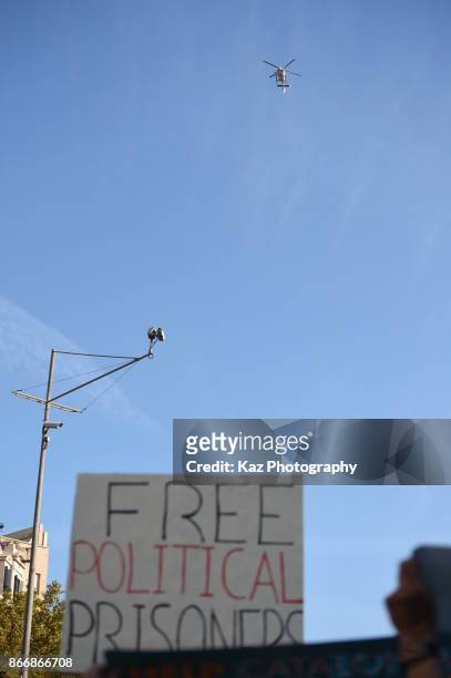 Police helicopters hover as protesters gather in the city centre to demonstrate against the Spanish federal government's move to suspend Catalonian...