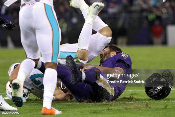 Quarterback Joe Flacco of the Baltimore Ravens is tackled by middle linebacker Kiko Alonso of the Miami Dolphins during the second quarter at M&T...