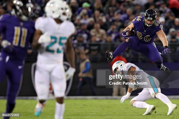 Tight End Nick Boyle of the Baltimore Ravens leaps over middle linebacker Kiko Alonso of the Miami Dolphins in the second quarter at M&T Bank Stadium...