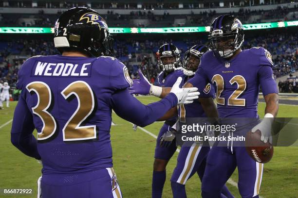 Cornerback Jimmy Smith and free safety Eric Weddle of the Baltimore Ravens celebrate after a touchdown in the fourth quarter against the Miami...