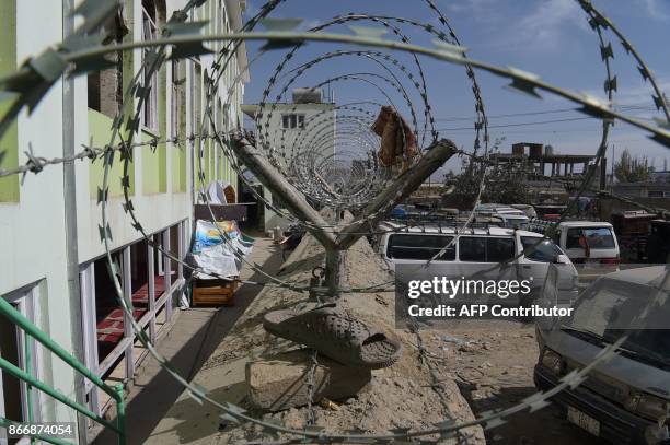 In this photograph taken on October 23, 217 a sandal belonging to a victim hanging on barbed wire outside the Imam Zaman Shiite mosque after a...