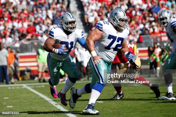 Ezekiel Elliott of the Dallas Cowboys rushes behind Travis Frederick during the game against the San Francisco 49ers at Levi's Stadium on October 22,...