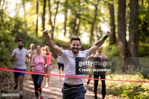 Happy marathon runner winning and crossing finish line with arms raised. Happy marathon runner winning and crossing finish line with arms raised.