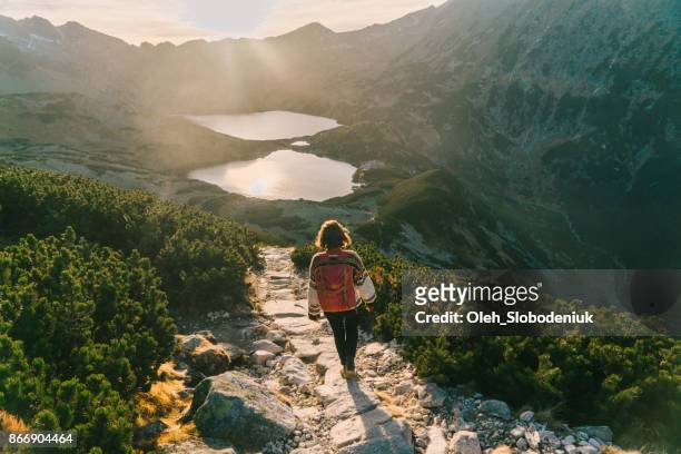 mujer caminando cerca del lago en las montañas de tatra - turismo ecológico fotografías e imágenes de stock