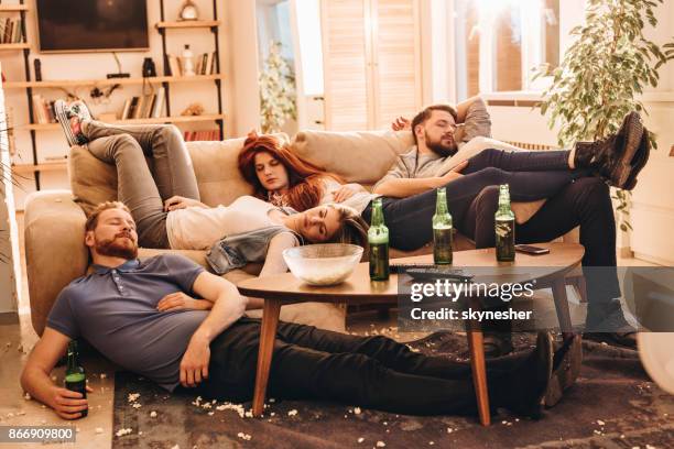 grupo de amigos perdidos durmiendo después de fiesta en la sala de estar. - passed out drunk fotografías e imágenes de stock