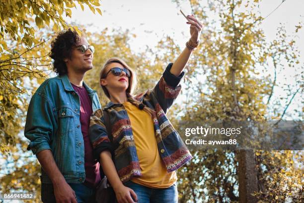 young couple in park making selfie - park man made space stock pictures, royalty-free photos & images