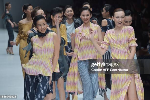 This picture taken on October 26, 2017 shows Indonesian models presenting Indonesian traditional fabrics called Ikat by designer Didiet Maulana...