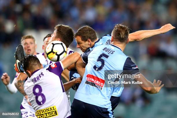 Alex Wilkinson of Sydney FC heads the ball at goal under pressure for the Glory defenders during the round four A-League match between Sydney FC and...