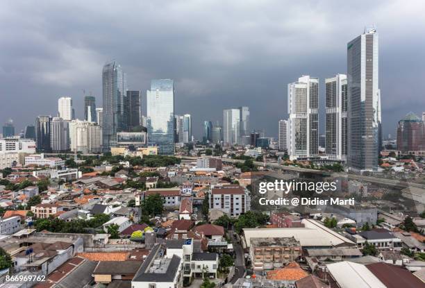 threatening clouds over jakarta skyline, indonesia capital city - jakarta slum stock pictures, royalty-free photos & images