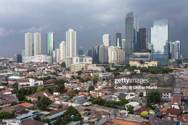 threatening clouds over jakarta skyline, indonesia capital city - jakarta slum stock pictures, royalty-free photos & images