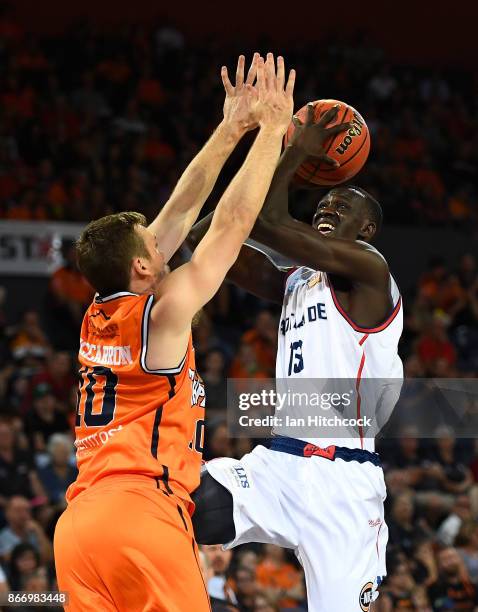 Majok Deng of the 36ers attempts a jump shot over Mitch McCarron of the Taipans during the round four NBL match between the Cairns Taipans and the...