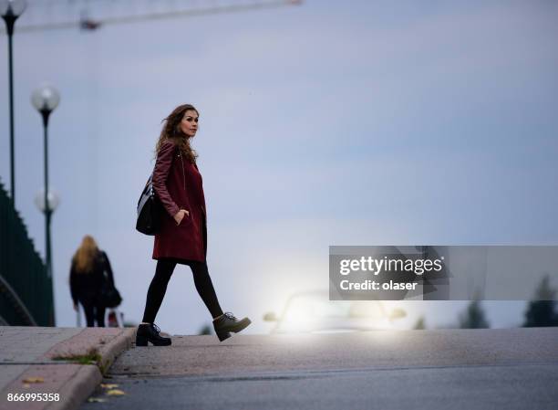 mujer cruce oscuro puente, coche en fondo - crossing fotografías e imágenes de stock