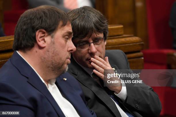 Catalan president Carles Puigdemont talks to Catalan regional vice president and chief of economy and finance Oriol Junqueras during a session of the...