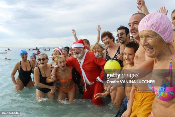 Une personne déguisée en Père Noël se baigne aux côtés de quelque deux cents participants, le 15 décembre 2002 à Nice, lors du traditionnel bain de...