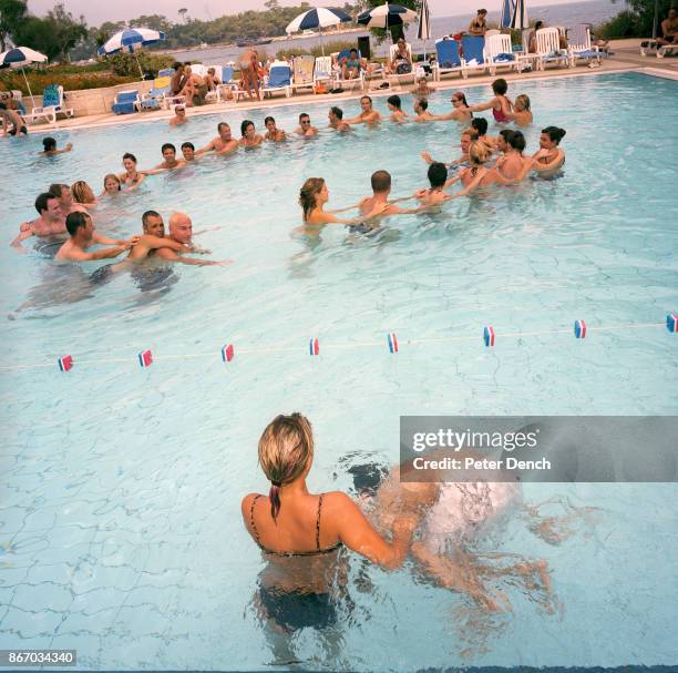 Visitors to a Club Med holiday village in Turkey do the Conga dance in an outdoor swimming pool. Club Méditerranée SA, commonly known as Club Med, is...