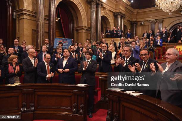 Catalan President Carles Puigdemont is seen with other members of Parliament as they react to the news that the Catalan Parliament has voted in...