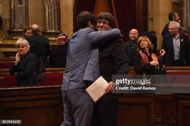 Catalan President Carles Puigdemont is hugged by Minister of Health Antoni Comín as they react to the news that the Catalan Parliament has voted in...