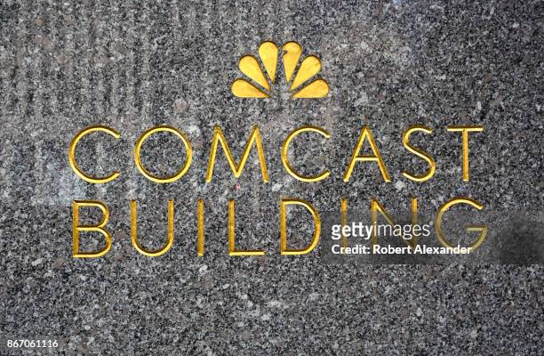 The NBC-TV network peacock logo embellishes a granite wall near the entrance to the Comcast Building in New York, New York. The Comcast Corporation...