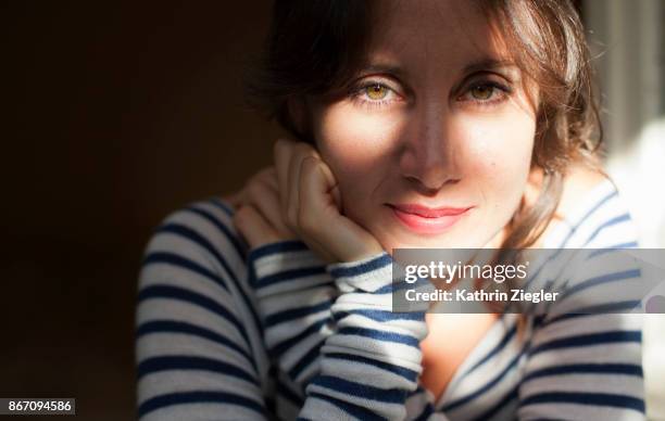 woman looking out of window, shadows across her face - woman shadow stock pictures, royalty-free photos & images