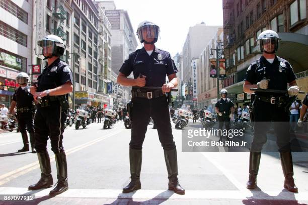 Los Angeles Police Department officers form a police line blocking the route to the Staples Center - site of the Democratic National Convention, on...