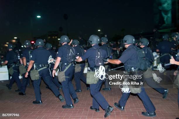 Los Angeles Police Department Riot Control units move forward to disperse demonstrators outside the Staples Center at the Democratic National...