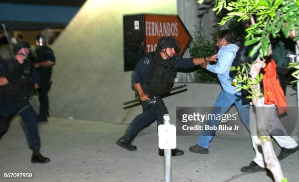 Los Angeles Police Department Riot Control units move forward to disperse demonstrators outside the Staples Center at the Democratic National...