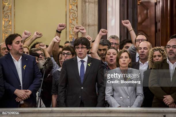 Carles Puigdemont, Catalonia's president, center, and Oriol Junqueras, Catalonia's vice president, center left, sing the Catalan anthem with...